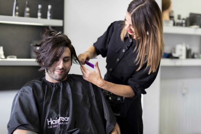 Il parrucchiere taglia i capelli a un uomo in un salone partner di Hairdreams