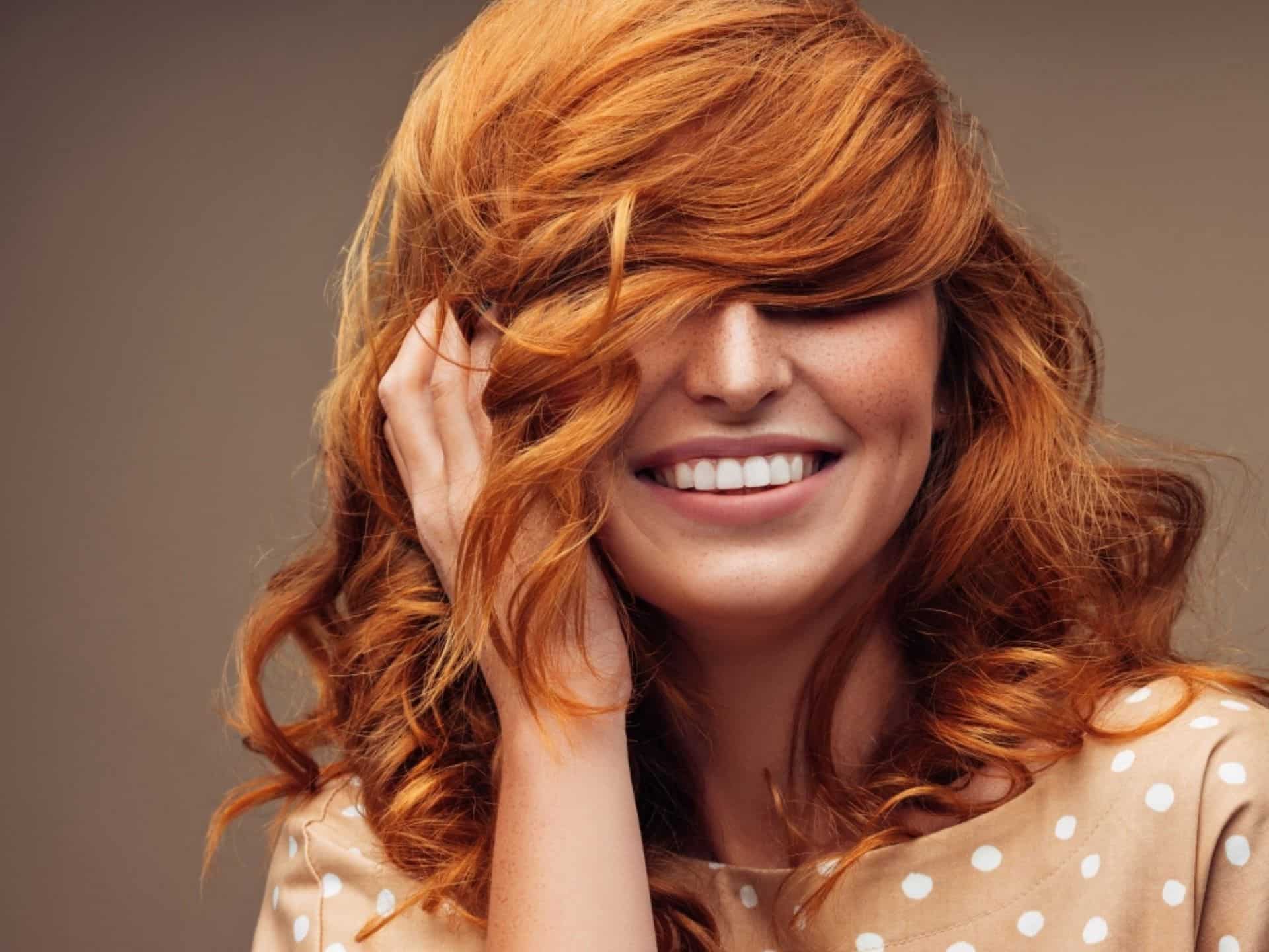 laughing woman with orange hair and freckles