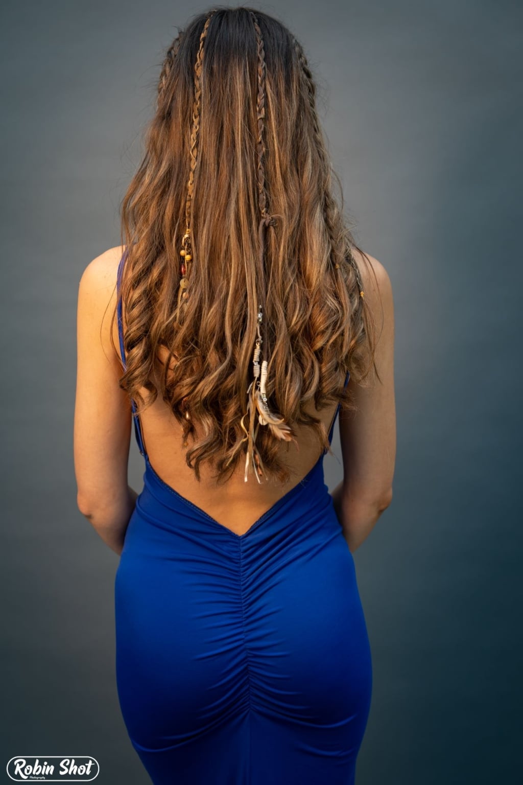 Une femme aux longs cheveux bruns porte les Hairdreams Leather Ribbons dans sa coiffure.
