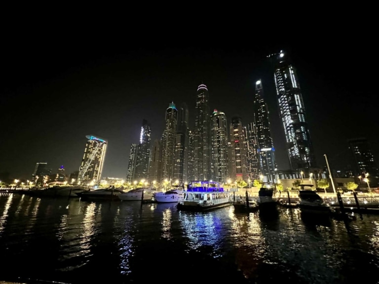 El puerto de Dubai de noche y al fondo los rascacielos