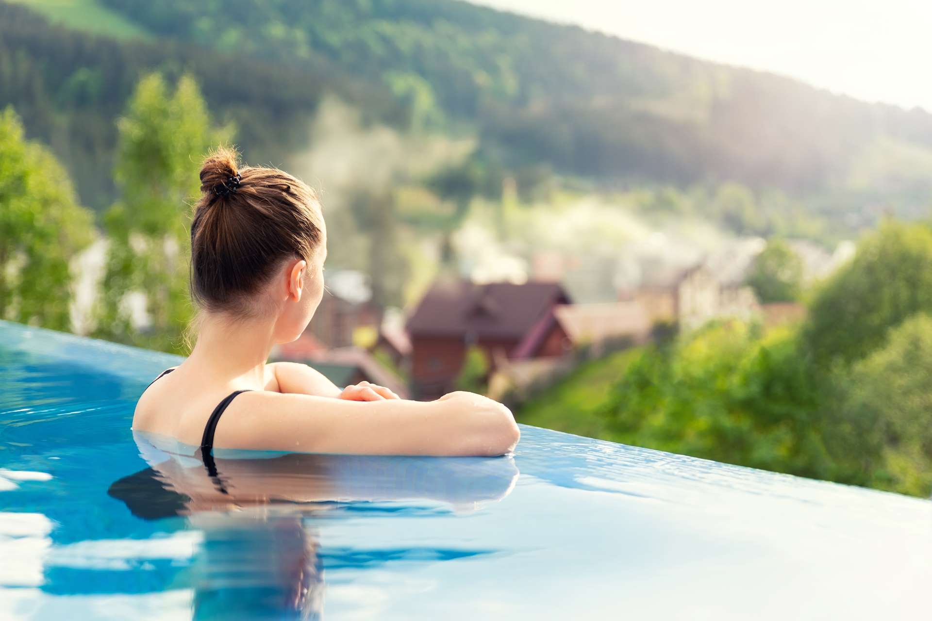 Femme dans la piscine contemplant le paysage styrien