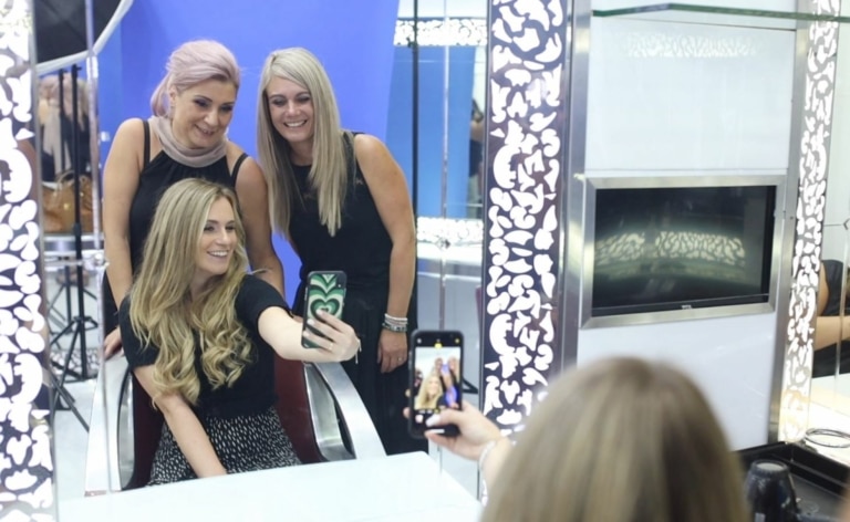 Una afortunada clienta se toma un selfie con sus peluqueros de Hairdreams