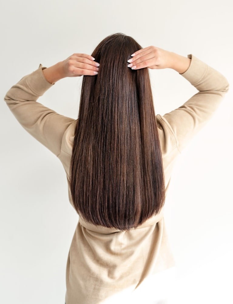 Frau mit langen braunen Haaren von hinten