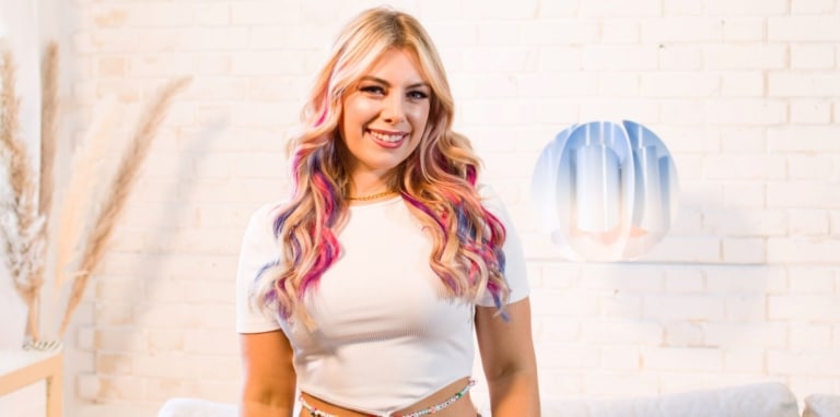 Woman with blonde hair wears colourful Hairdreams tape extensions in her hair.