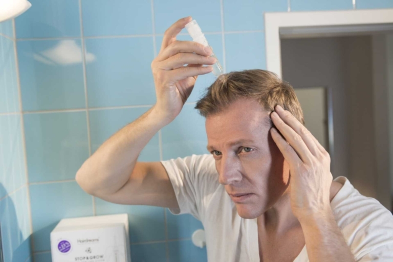 L'homme utilise Stop&Grow, solution anti-chute de cheveux créée par Hairdreams, à la maison