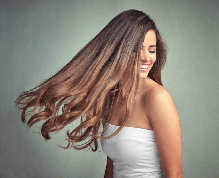 Frau mit braunen Haaren mit einer Haarverlängerung in den Längen und Spitzen von Hairdreams