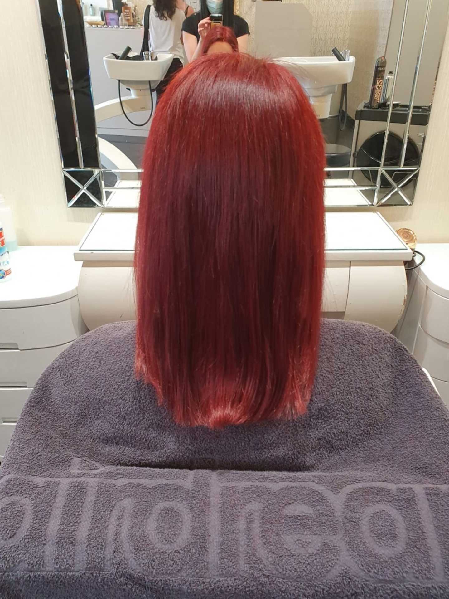 After hair thickening in lengths and tips in a woman with red hair