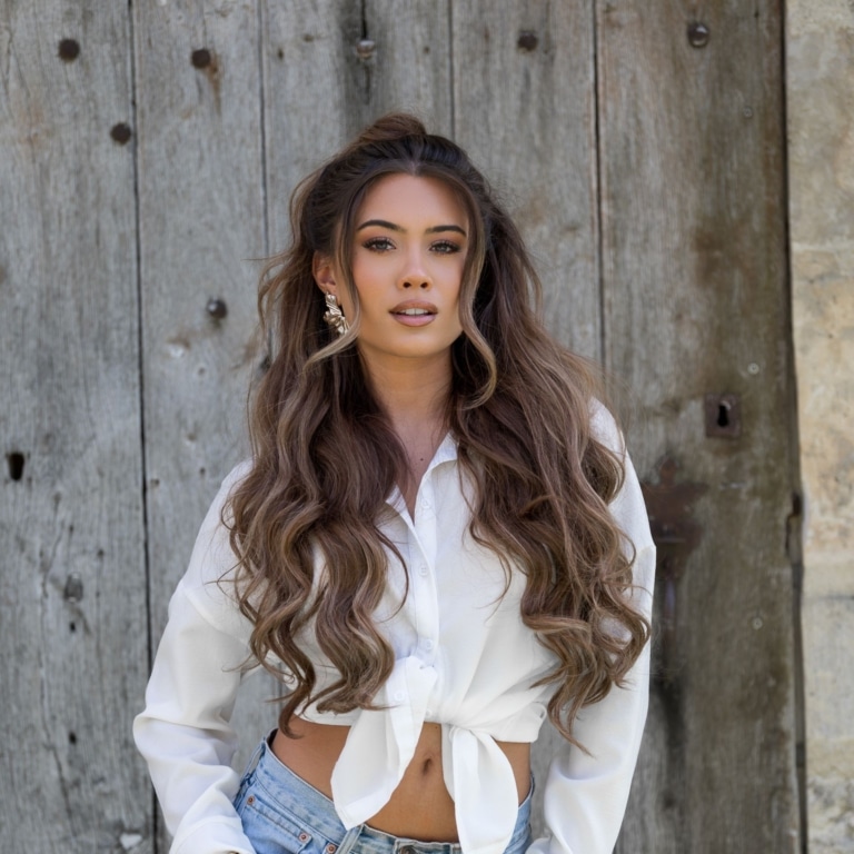 Mujer con pelo castaño y una extensión de pelo con mechas