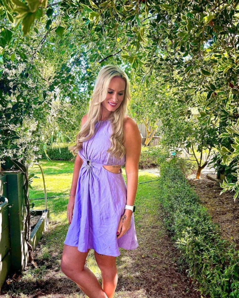Frau in einem lila Kleid mit ihrer schönen blonden Hairdreams-Mähne.