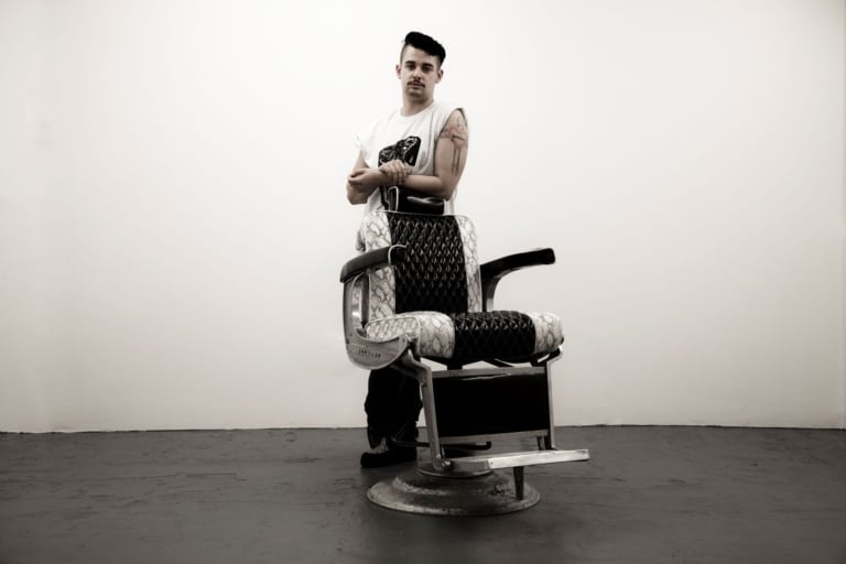 Charli le Mindu stands by a barber chair