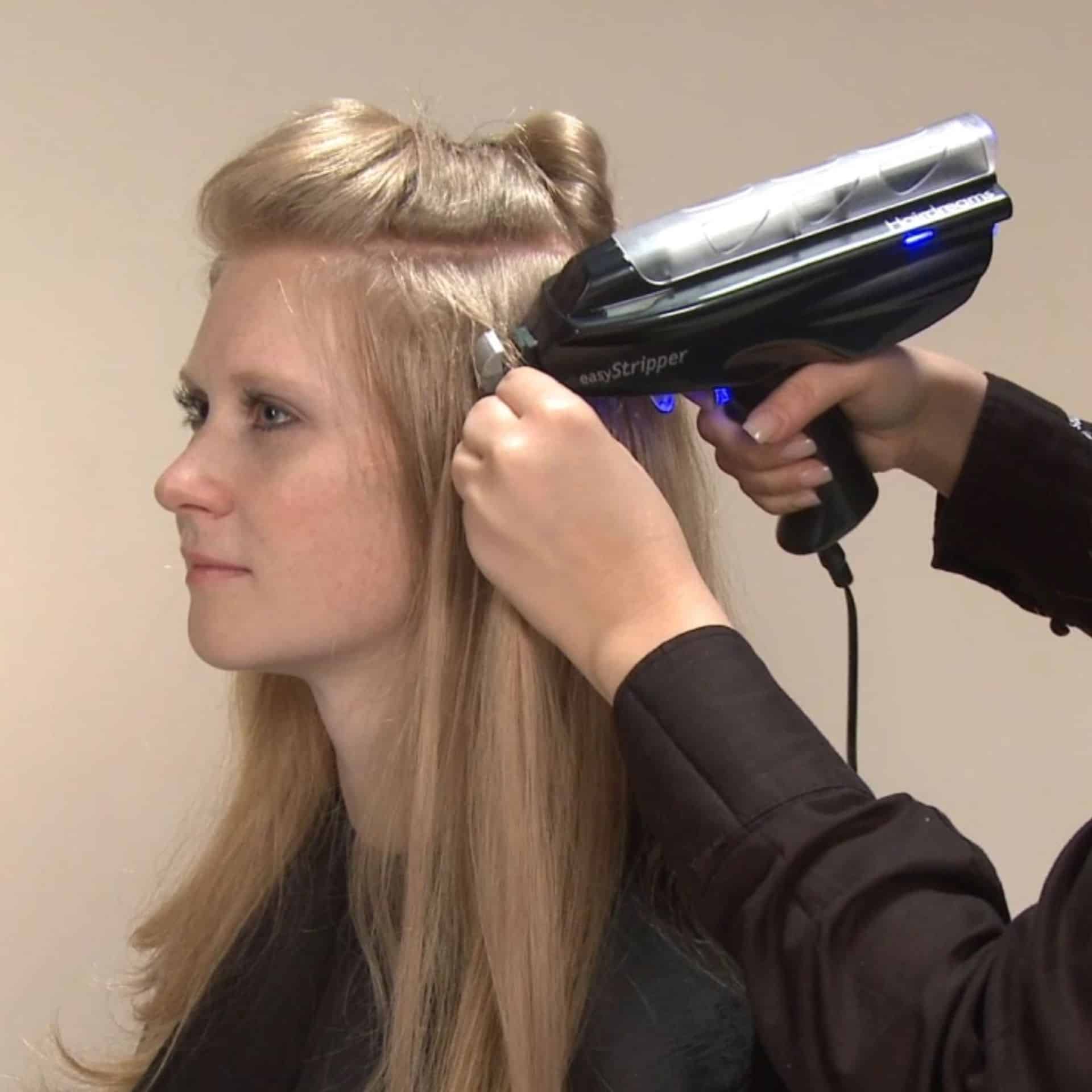 Una peluquera retira las extensiones adhesivas de una clienta con el EasyStripper de Hairdreams.