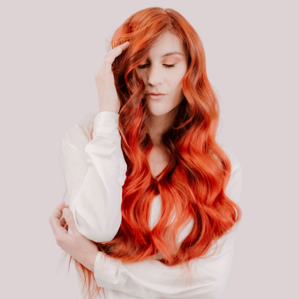 Frau mit langen gewellten roten Haaren