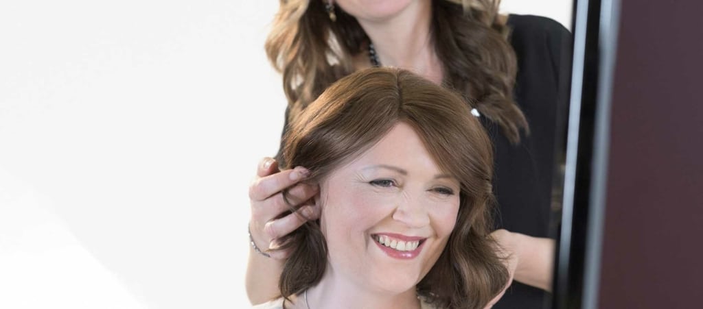 Une heureuse cliente aux cheveux bruns dans un salon de coiffure partenaire Hairdreams