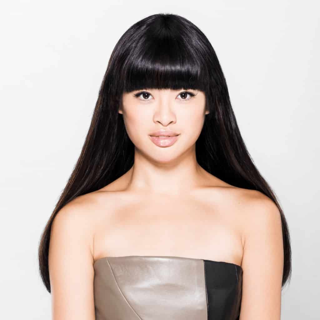 Asiatische Frau mit schwarzen langen Haaren und Stirnfranzen