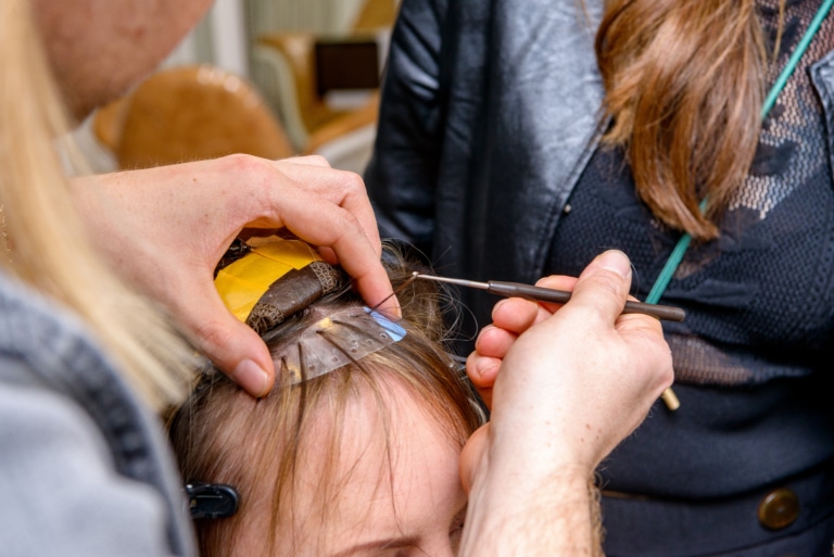 Haarsträhnen werden mithilfe eines Shields durchgezogen