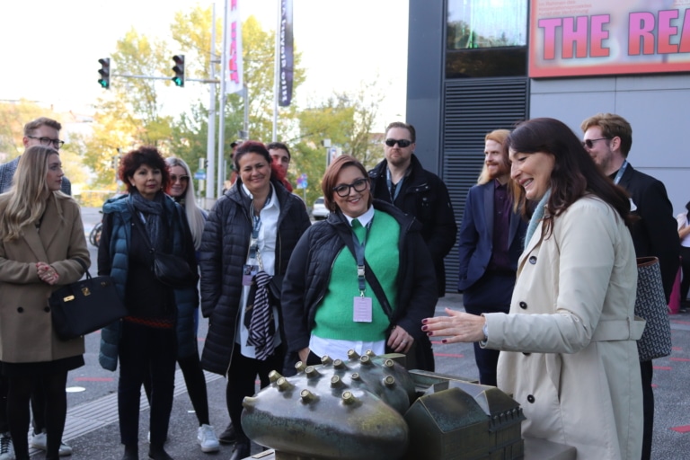 Menschen lauschen der Stadtführerin bei ihren Geschichten über Graz