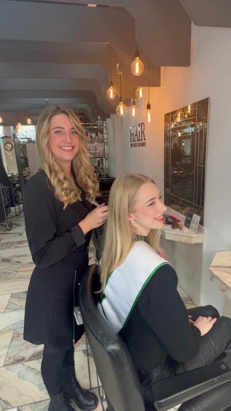 Une coiffeuse du salon partenaire Hairdreams à Dortmund et sa cliente rient dans l'image
