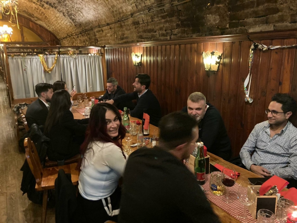 Die israelischen Gäste sitzen gemeinsam in einem traditionellen österreichischen Restaurant zum Abendessen am Tisch