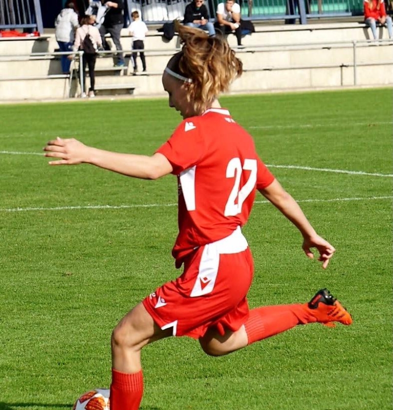 Une footballeuse qui porte des extensions Hairdreams donne un coup de pied